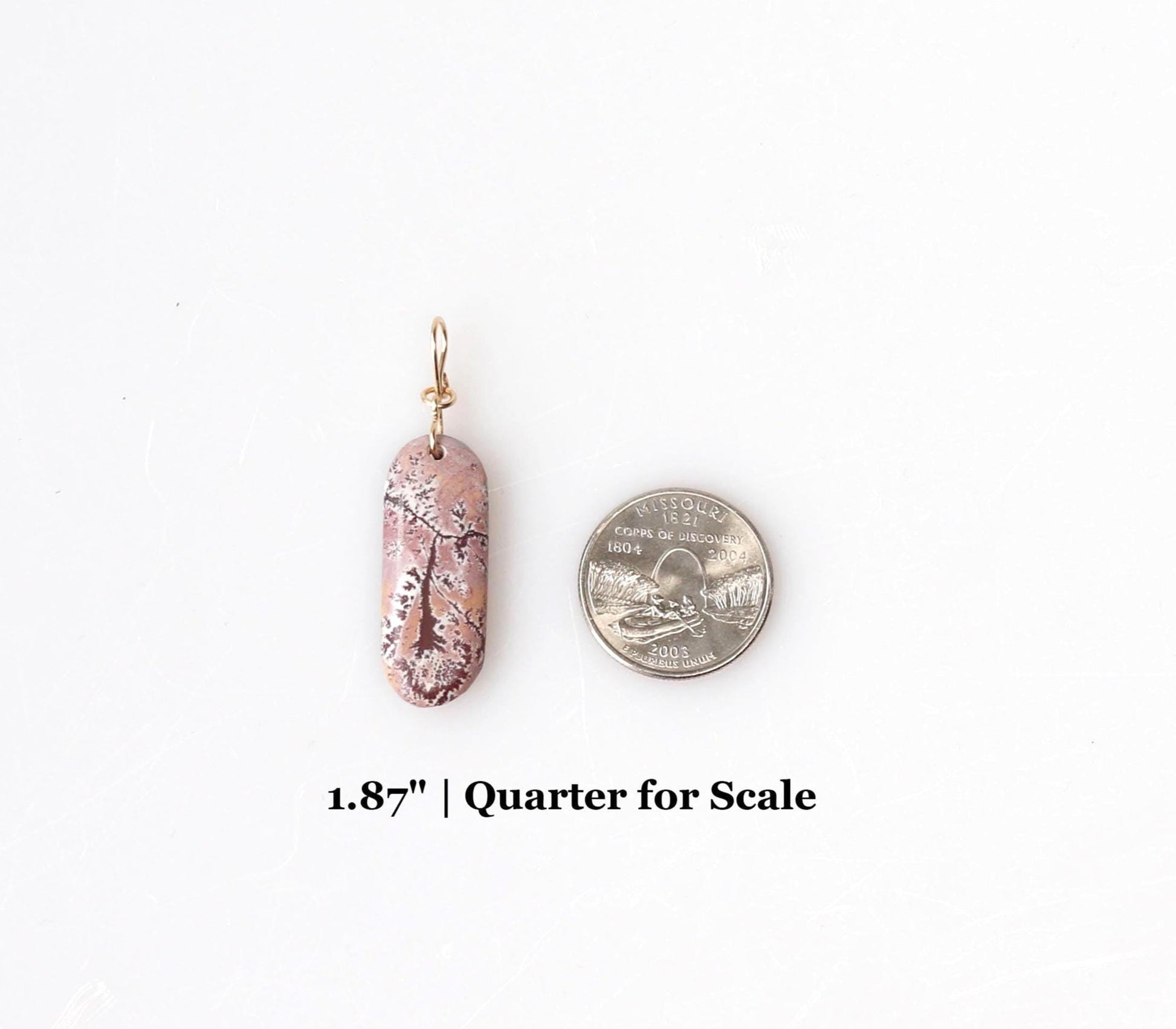 1.87 inch Sonoran Rhyolite  shown next to a Missouri quarter for scale on white background.