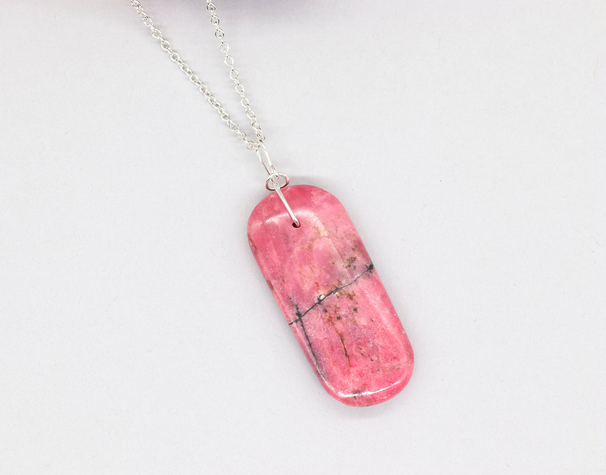 Natural Rhodonite pendant necklace with solid Argentium 935 Silver bail and chain shown on light gray background.