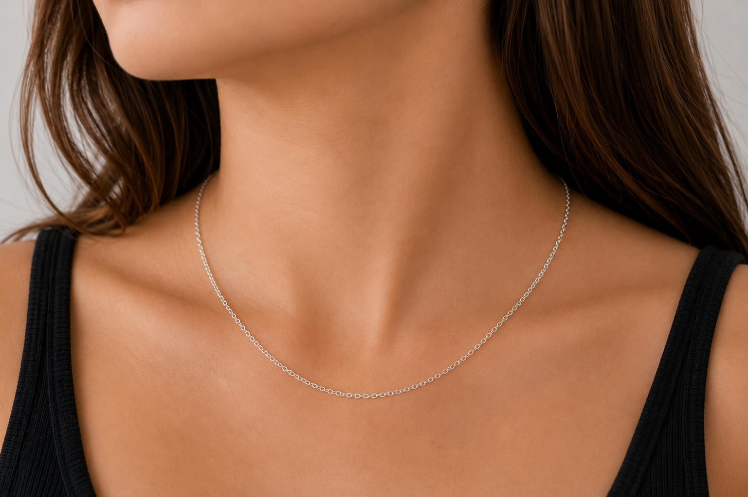 Argentium Silver oval chain necklace on a person wearing a black top against a neutral background
