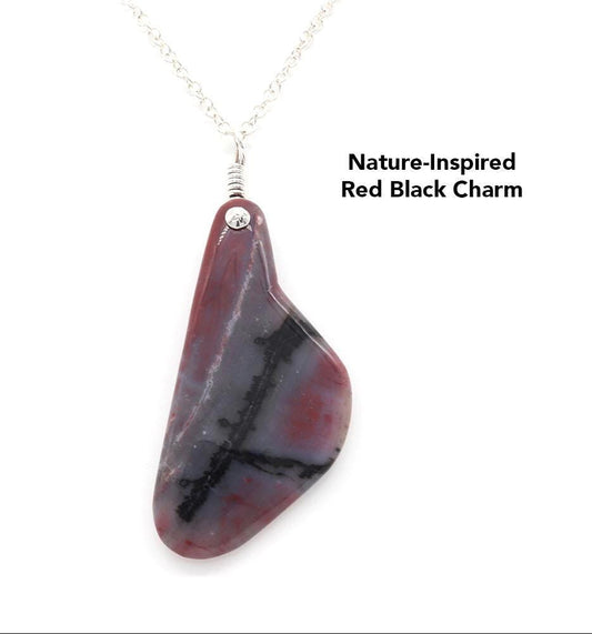 Handcrafted Arizona Petrified Rainbow Wood charm, 4 inches long, with a 935 silver bail, displayed against a white background, showcasing bold red and carbon black stripes and swirls in an asymmetrical teardrop shape, highlighting its nature-inspired design suspended from a 935 Argentium Chain not included in purchase.