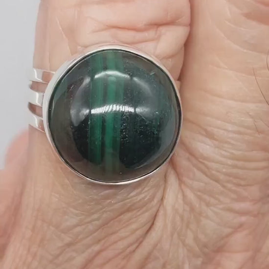 Handcrafted natural green Malachite ring with oval cabochon, polished fine silver bezel and solid Argentium 935 silver split-shank band.  Demo clip shows the ring on a hand for display.