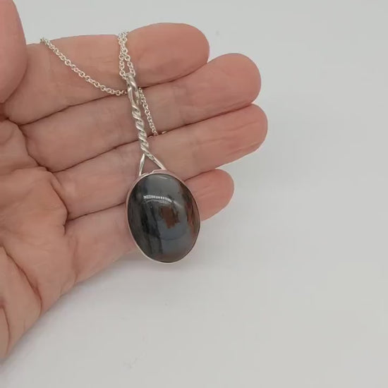 Short Demo clip of Pendant of Petrified Wood set in Argentium silver shown in palm of hand.