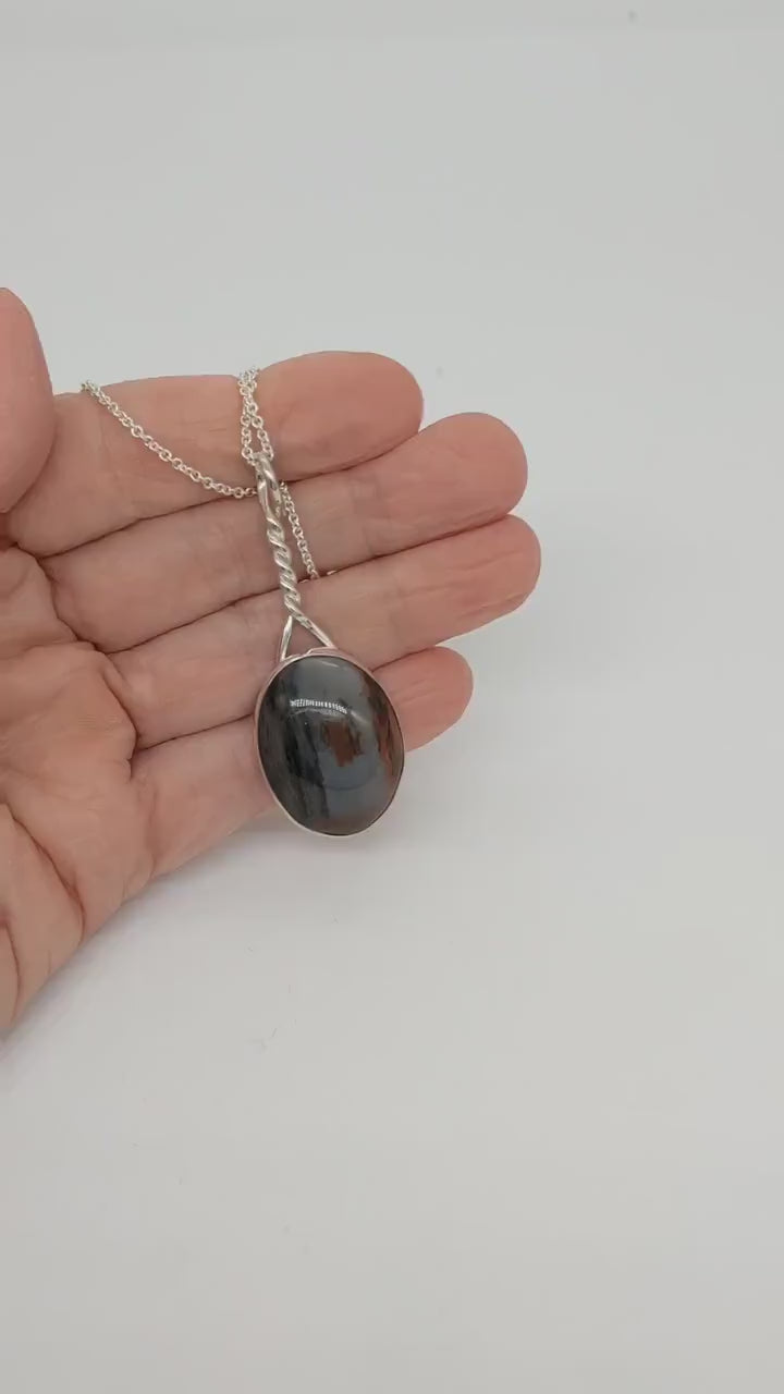 Short Demo clip of Pendant of Petrified Wood set in Argentium silver shown in palm of hand.
