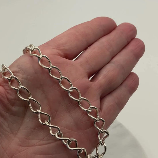 Video showing a solid Argentium® silver oval link necklace resting in a hand, demonstrating its weight and shine. On-screen text reads: “Solid — not hollow,” “45 grams Argentium® silver,” and “Made to wear every day.