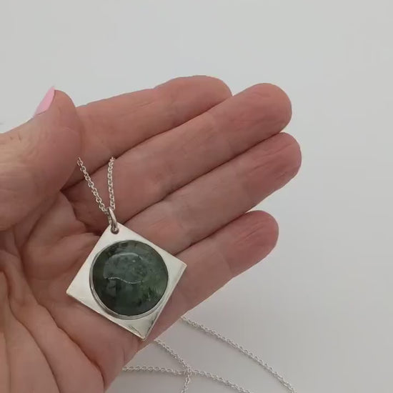 Demo clip of Wyoming Jade cabochon set in solid Argentium silver shown in palm of hand against white background.