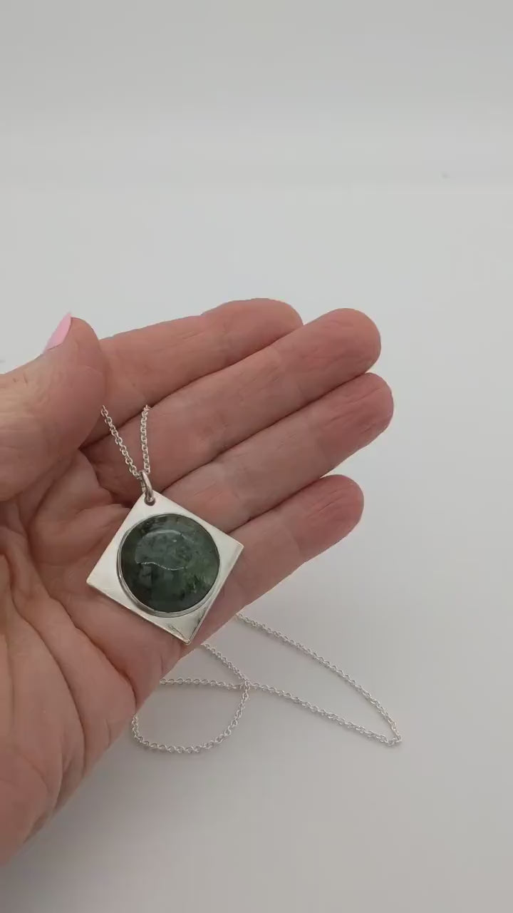 Demo clip of Wyoming Jade cabochon set in solid Argentium silver shown in palm of hand against white background.