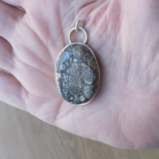 Demo in hand of this Natural Turritella Agate fossil pendant in Argentium 935 Silver with silver chain
