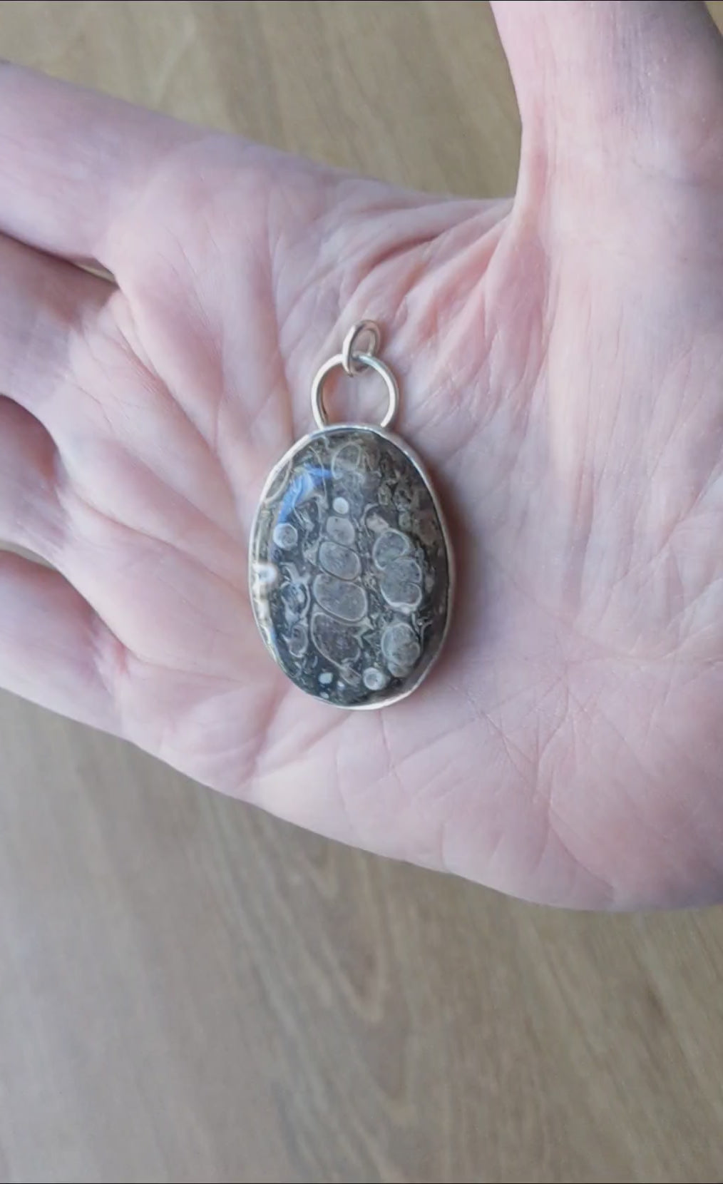Demo in hand of this Natural Turritella Agate fossil pendant in Argentium 935 Silver with silver chain
