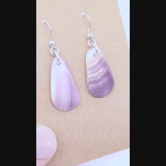 Demo Clip of human hand showing the highlights of Quahog handcrafted earrings.