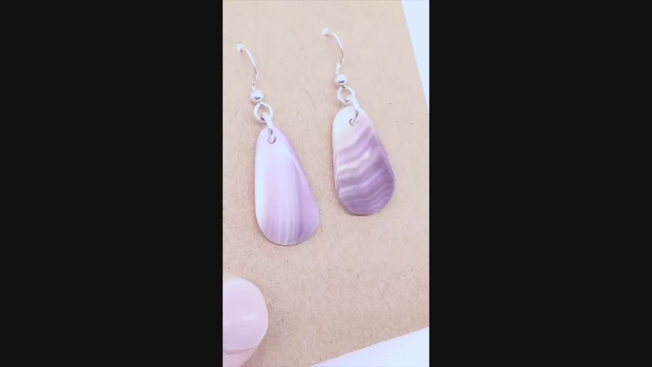 Demo Clip of human hand showing the highlights of Quahog handcrafted earrings.