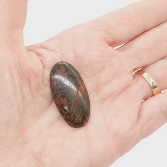 Demo clip of Red Jasper Cabochon shown in palm of hand on white background.