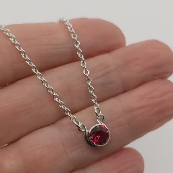 Lab Ruby Necklace demo video clip shown in palm of hand against white background.