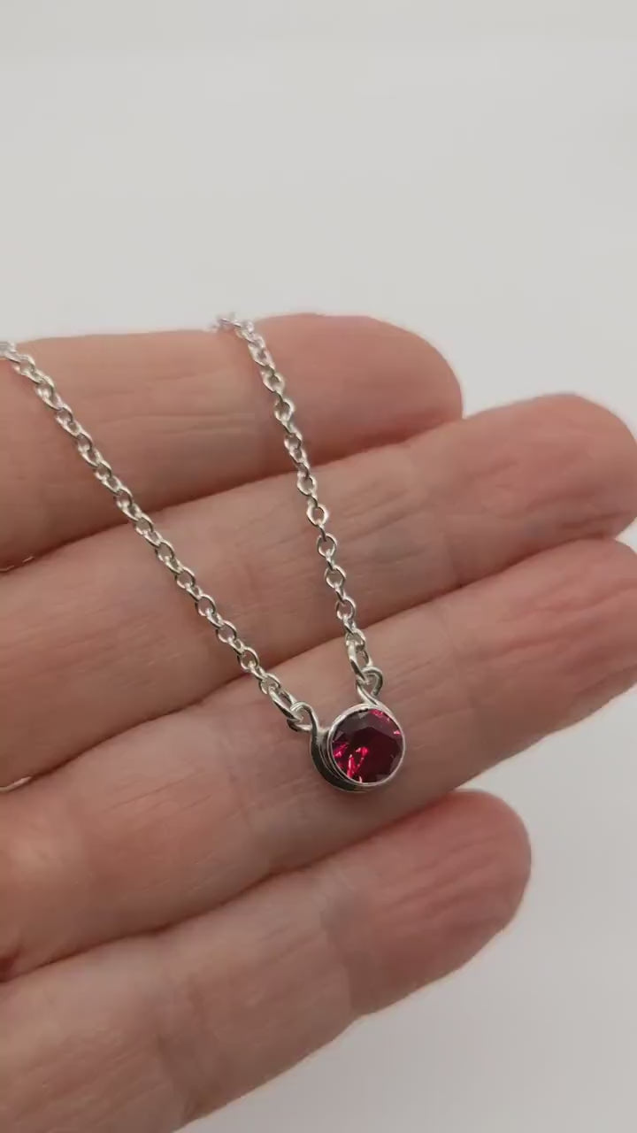 Lab Ruby Necklace demo video clip shown in palm of hand against white background.