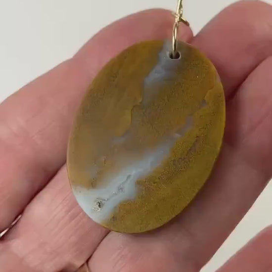 Sonoran Sunrise demo clip in palm of hand displaying the warm golden ochre tones with soft white veining and natural inclusions and Smooth, balanced shape with an easy, everyday feel.