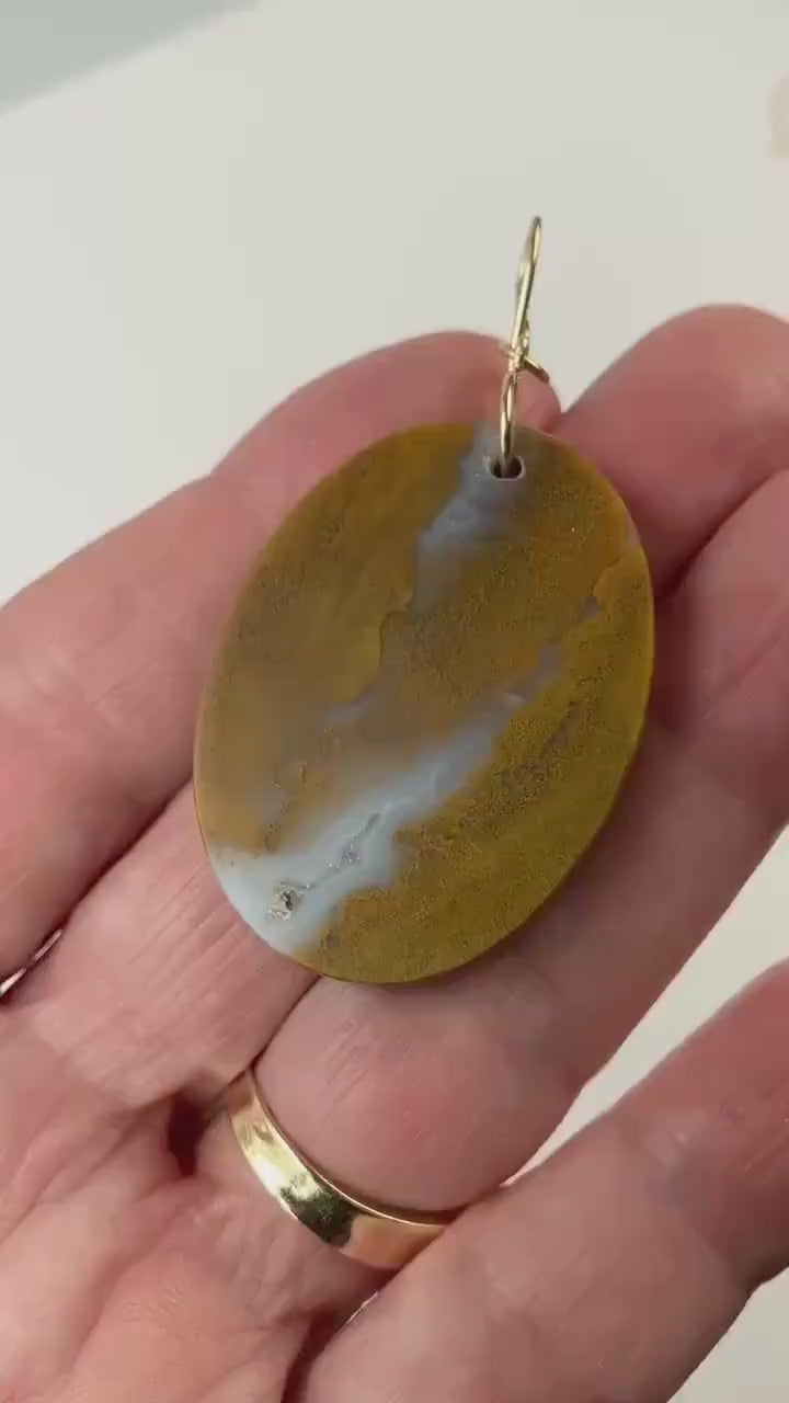 Sonoran Sunrise demo clip in palm of hand displaying the warm golden ochre tones with soft white veining and natural inclusions and Smooth, balanced shape with an easy, everyday feel.