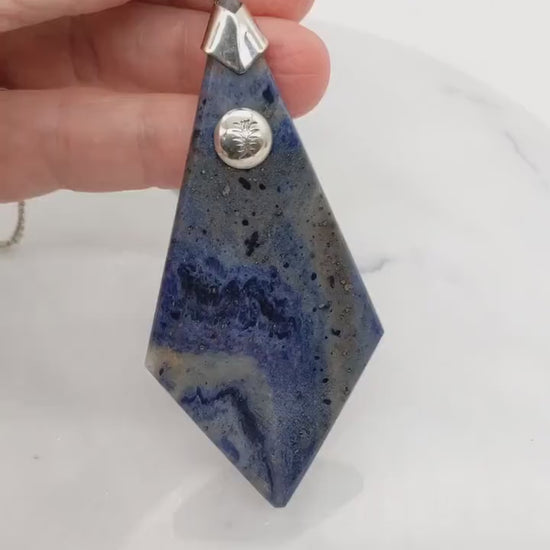 Demo clip in hand featuring this Blue Foidolite pendant necklace with solid Argentium Silver bail and chain