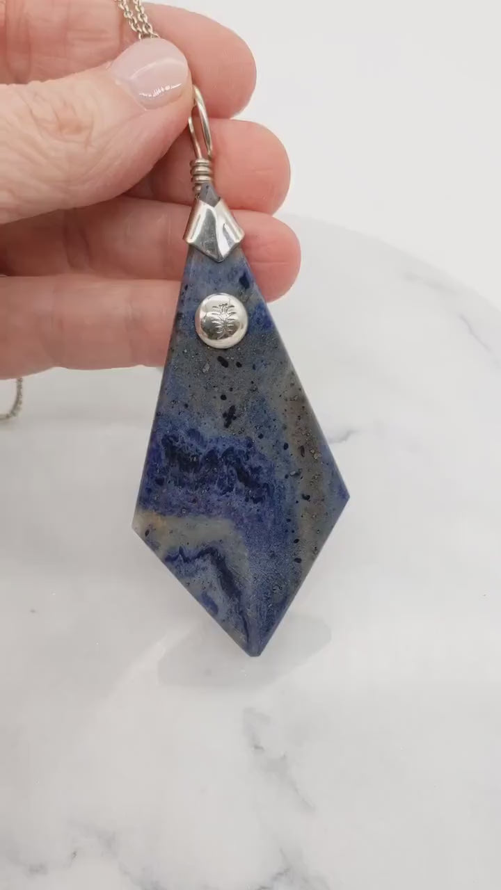 Demo clip in hand featuring this Blue Foidolite pendant necklace with solid Argentium Silver bail and chain
