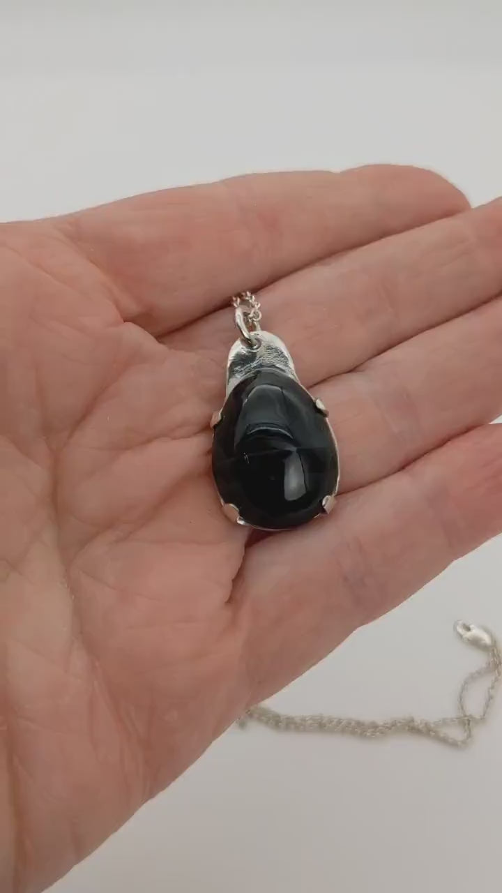 Demo clip in hand demonstration the features of this Blue Tiger's eye pendant necklace.