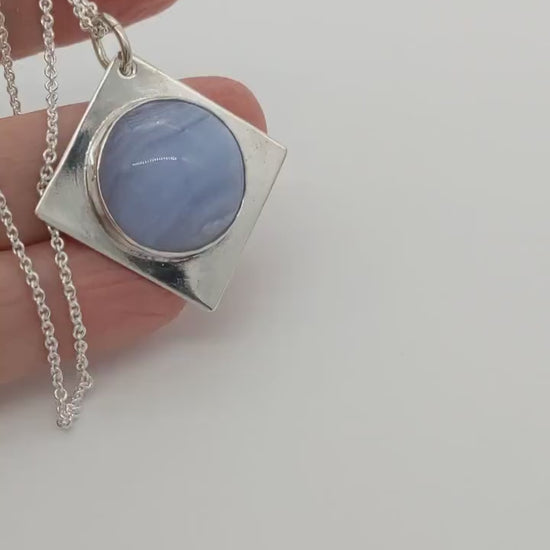 Blue Lace Agate Pendant in Argentium Silver shown in human hand demo of the features and shine of the pendant.