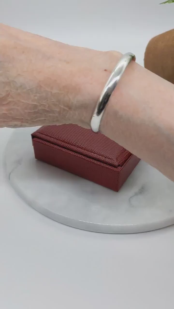 A demo clip of this silver Cuff bracelet handcrafted in solid Argentium® 935. The gently curved low dome profile gives this cuff its sleek, modern look, while the open design allows for slight adjustability.