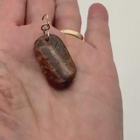 Demo clip of stony creek pendant with argentium silver custom bail in palm of hand against white background.