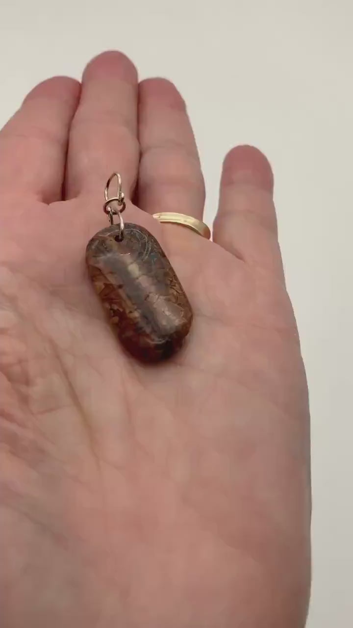 Demo clip of stony creek pendant with argentium silver custom bail in palm of hand against white background.