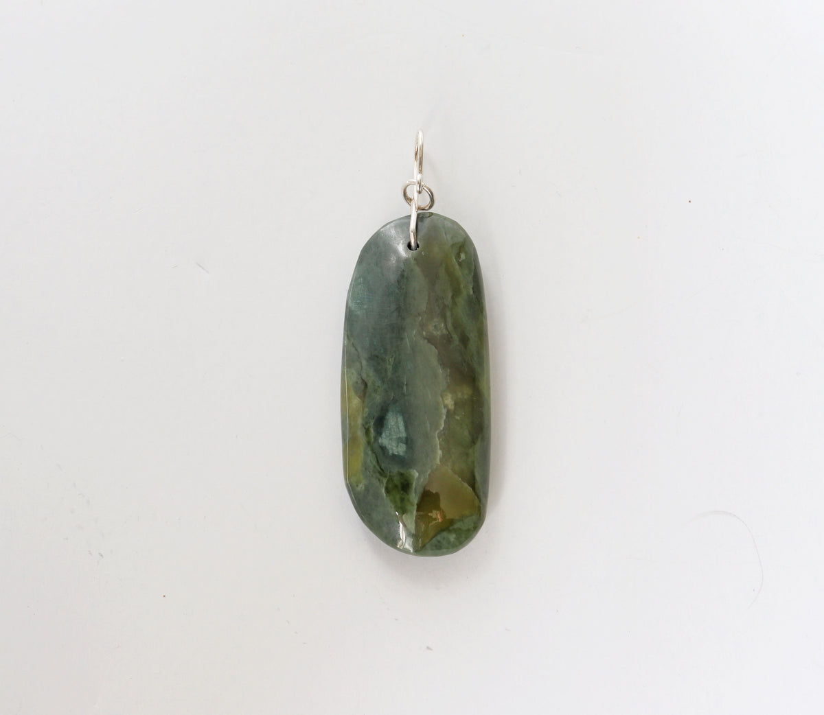 Green jade stone pendant on a white background
