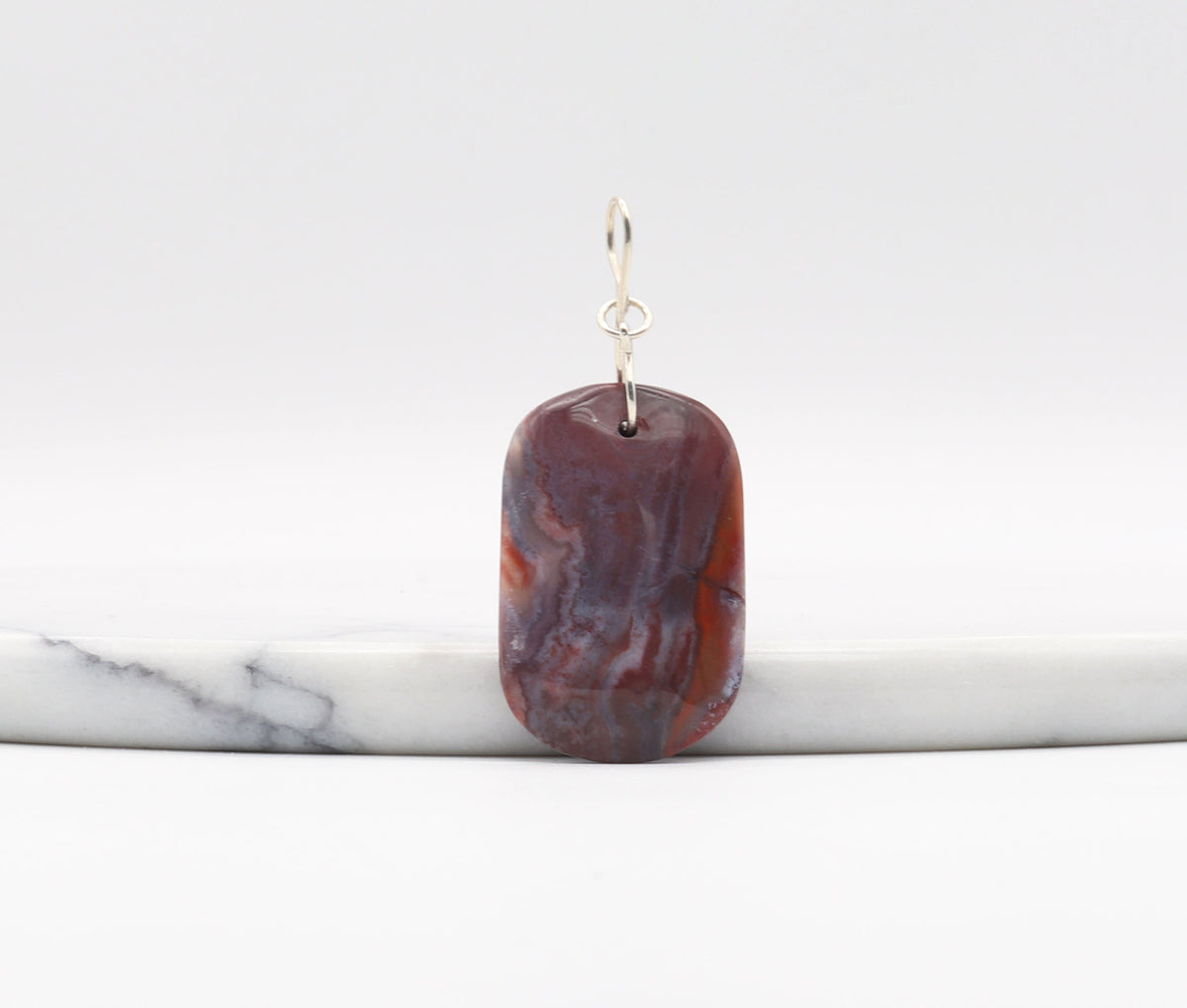 Red Mexican agate shown against white marble background.