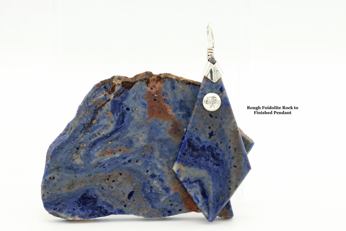 Blue Foidolite pendant necklace with solid Argentium Silver bail and chain, shown on a white background with a text label. Text reads Rough Foidolite Rock to Finished Pendant'