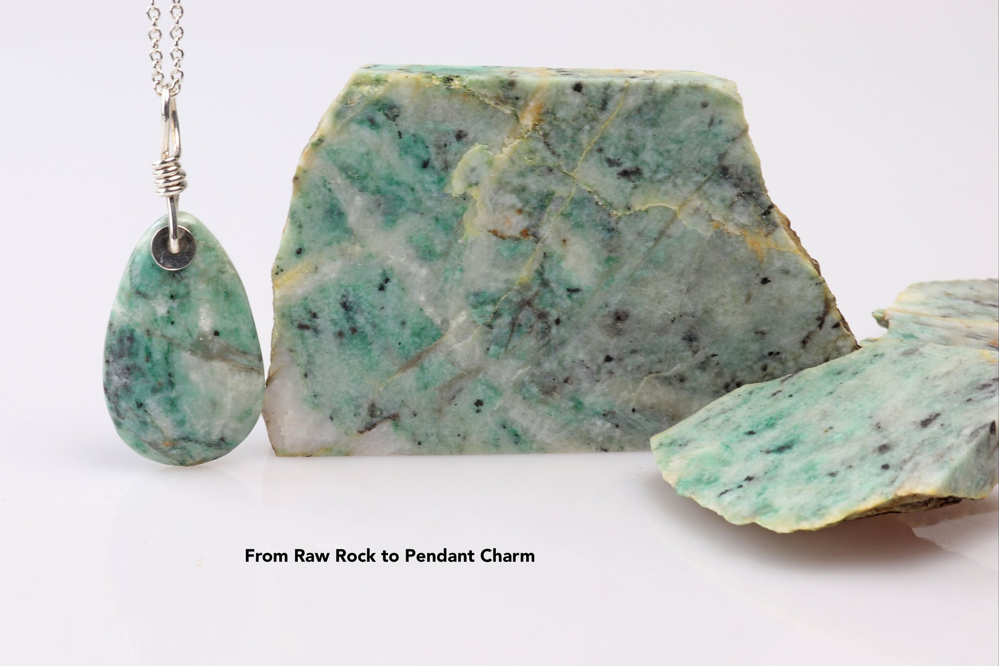 Handcrafted African Turquoise pendant with Argentium 935 Silver bail, 57.15mm, placed next to a raw African Turquoise Jasper rock (for illustration only, not for sale) on a white background, showcasing blue-green hues and matrix patterns.