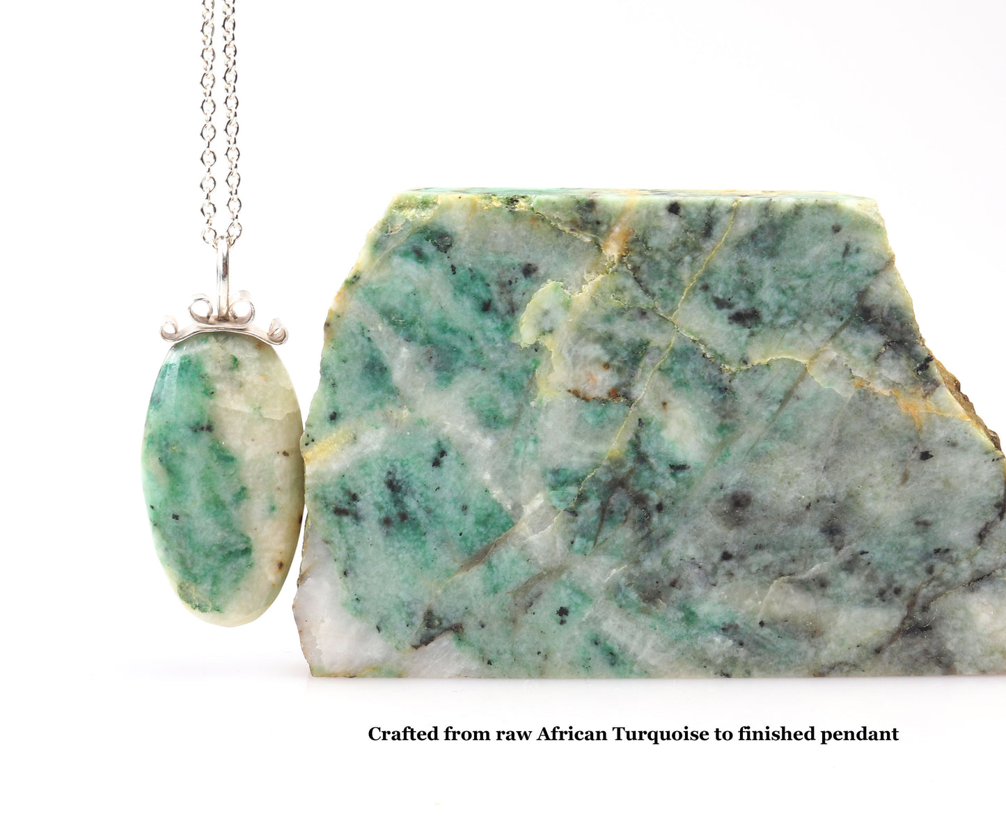 Raw African turquoise stone with a pendant on a white background.