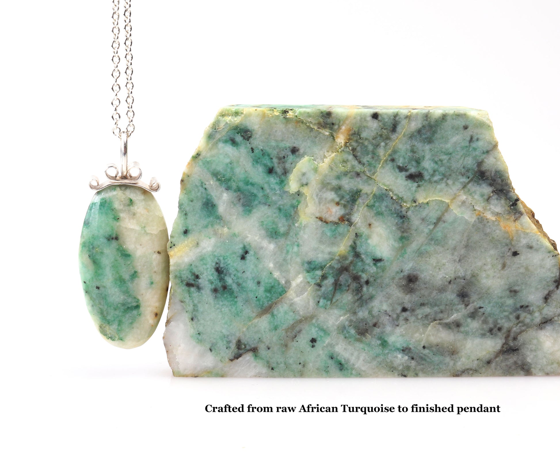Raw African turquoise stone with a pendant on a white background.