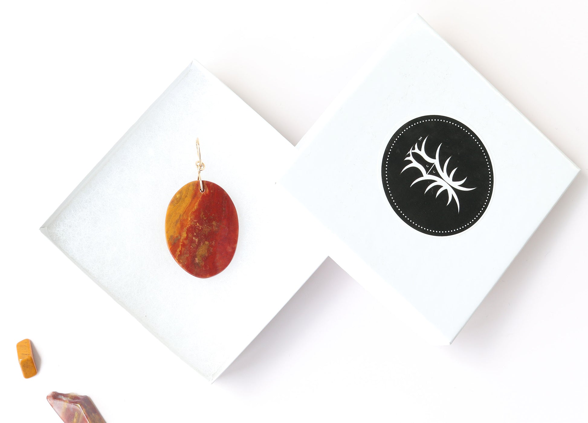 Sonoran Sunrise pendant shown in white gift box with adjacent lid displaying the Elkhorn Silver brand and sonoran sunrise pebbles for props.