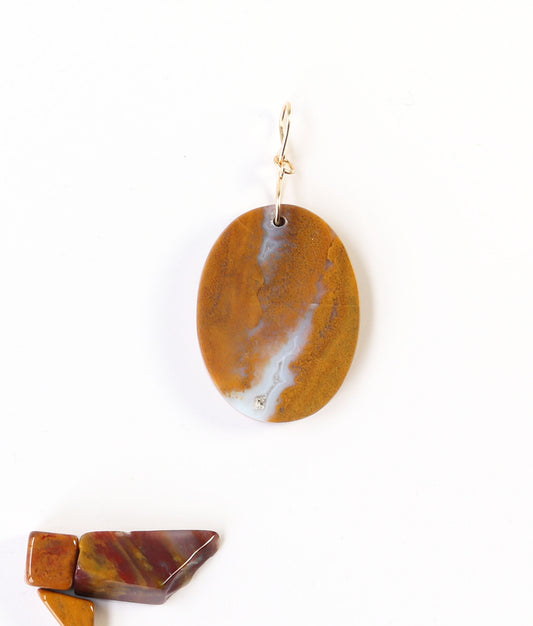 One-of-a-Kind Sonoran Sunrise Pendant – Hand-Cut in Missouri with warm golden ochre tones with soft white veining and natural crystal inclusions. Shown on white background with pebbles of polished sonoran sunrise shown for props.
