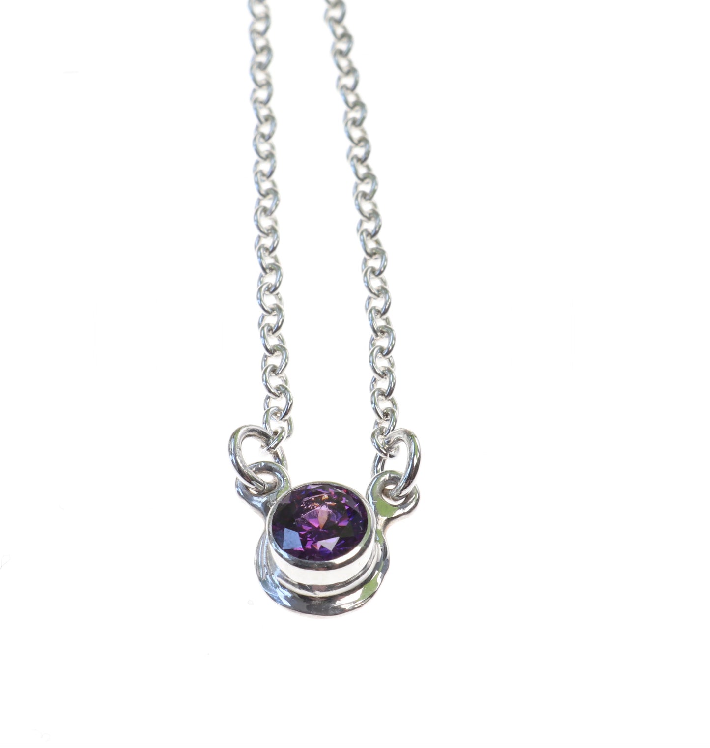 Front view of purple zirconia set in Argentium Silver with attached 1.9 silver chain 18inch shown on white background .