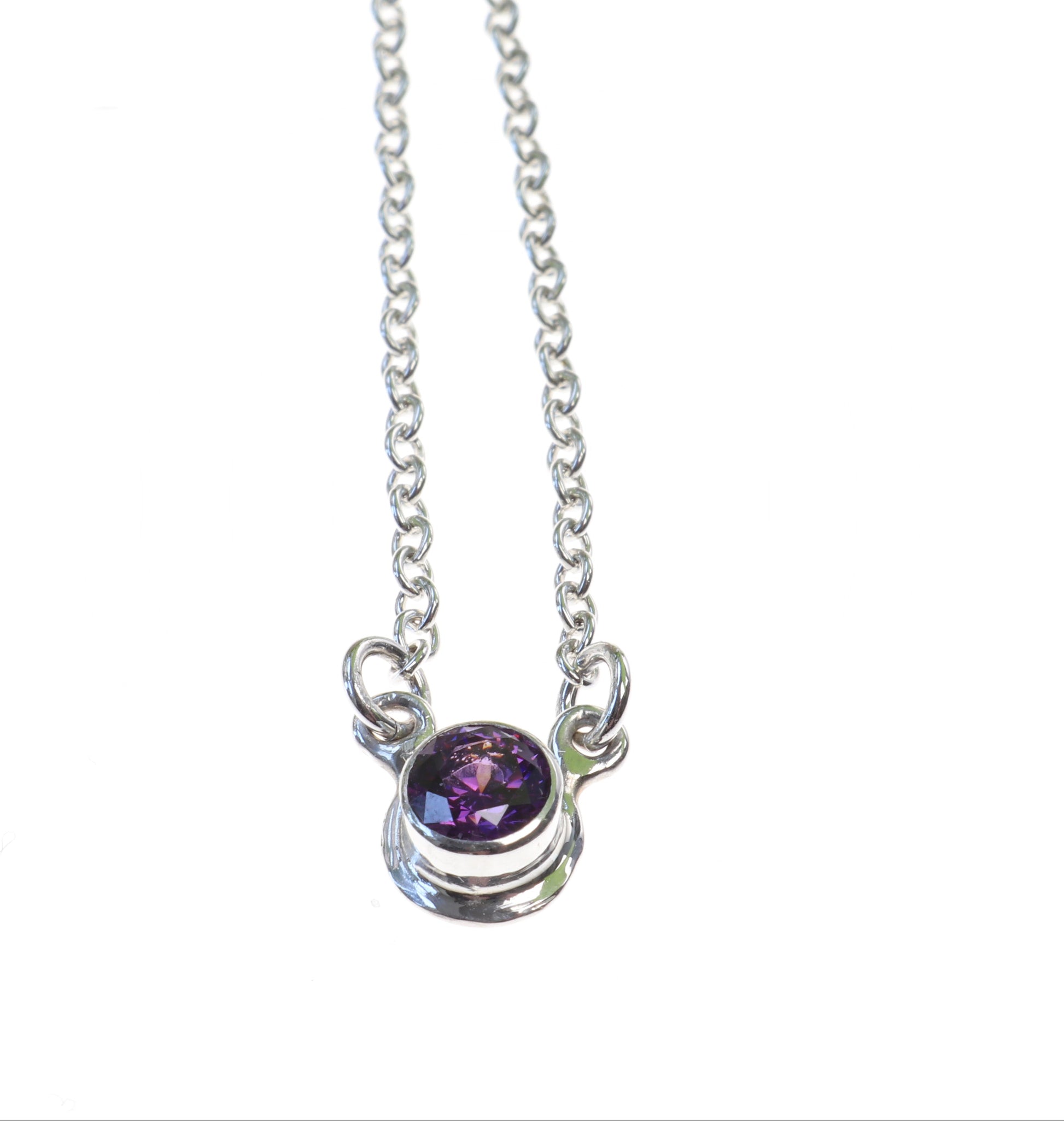Front view of purple zirconia set in Argentium Silver with attached 1.9 silver chain 18inch shown on white background .