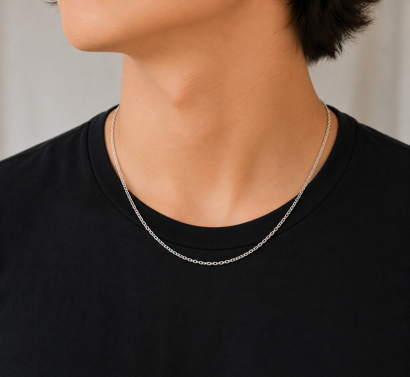 Argentium Silver oval chain necklace on a person wearing a black top against a neutral background