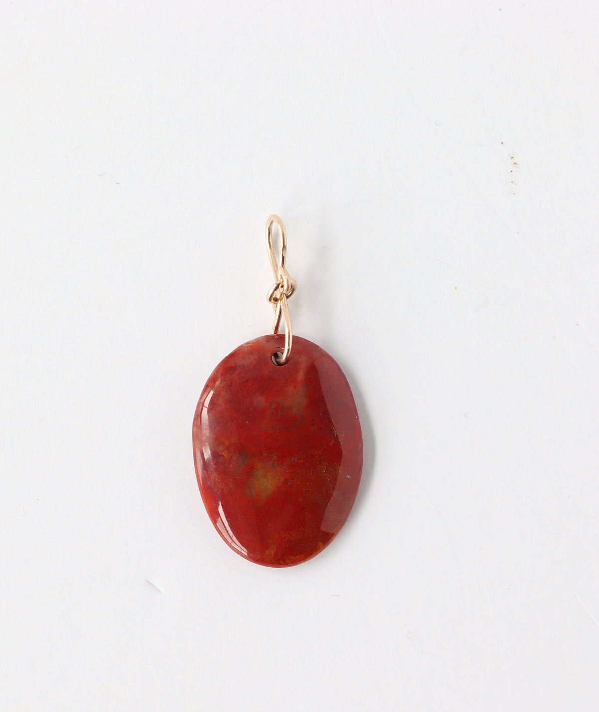 One-of-a-kind Sonoran Sunrise pendant, polished on both sides and finished with a handcrafted 14/20 gold-filled infinity bow-style bail.The jewelry is set against a white background.