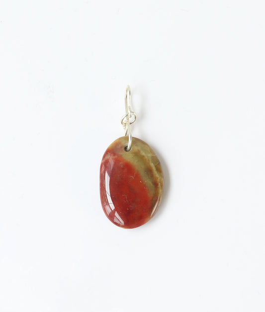 Oval-shaped sonoran sunrise pendant with a red and green color pattern on a white background